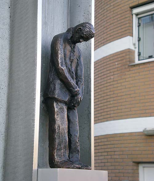 Reparatie/restauratie van een betonnen sokkel met bronzen beeld.