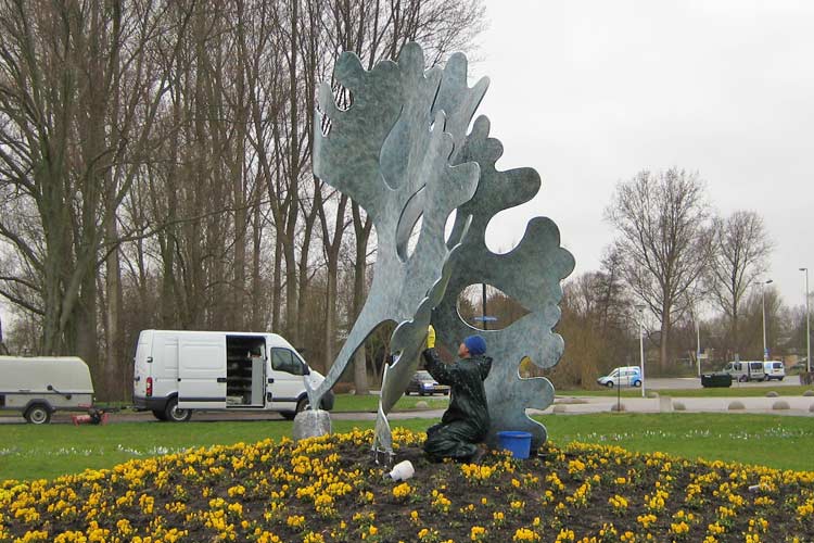 Het beeld  Algje  Stalen beeld met voet. (Pseudopalmata) van Jerome Symons in Hellevoetsluis ontdaan van alg cq mos en vuil.